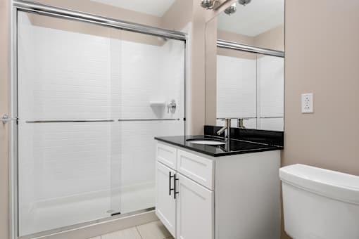 A bathroom with a white tub, sink, and shower.