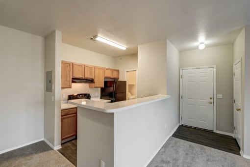 an open kitchen with a counter top and a door to a living room