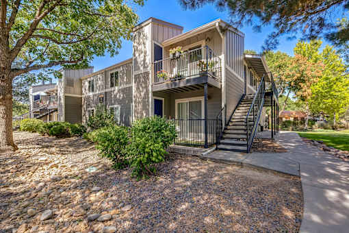 A modern two-story apartment building with a balcony and staircase.