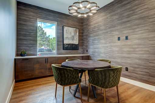 a dining room with a round table and chairs