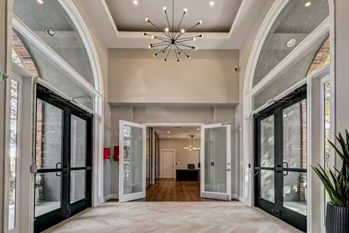 a foyer with glass doors and a chandelier