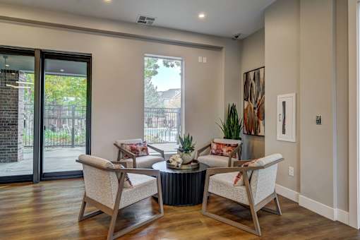 a living room with chairs and a table and a sliding glass door