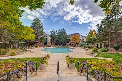 a view of a swimming pool with trees and a building in the background