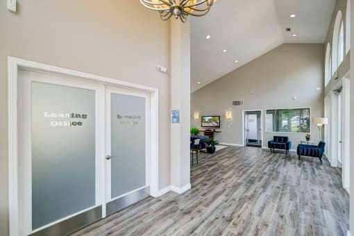 a large lobby with doors and chairs and a chandelier