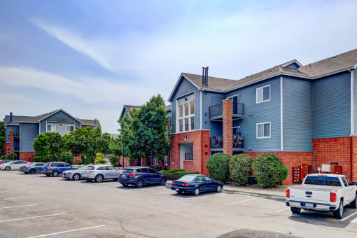 an empty parking lot in front of an apartment building