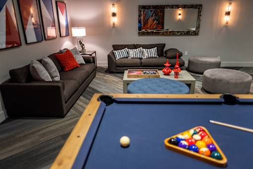 A pool table with a white ball and a triangle of balls on it.