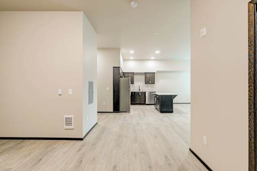 A kitchen area with a refrigerator, cabinets, and a countertop.