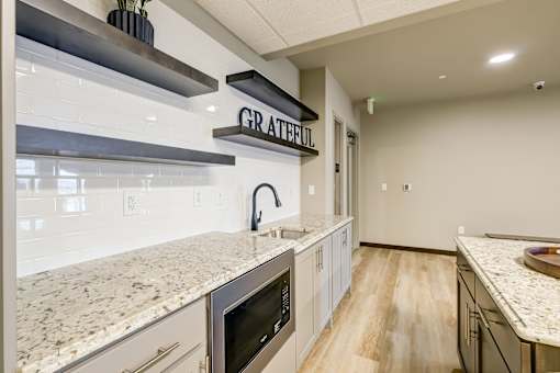 A kitchen with a granite countertop and a sign that says "GRATEFUL".