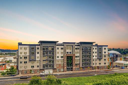 A modern apartment building with a green lawn in front.