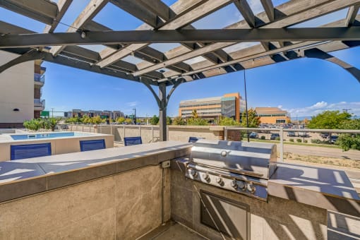 a gas grill on a patio with buildings in the background