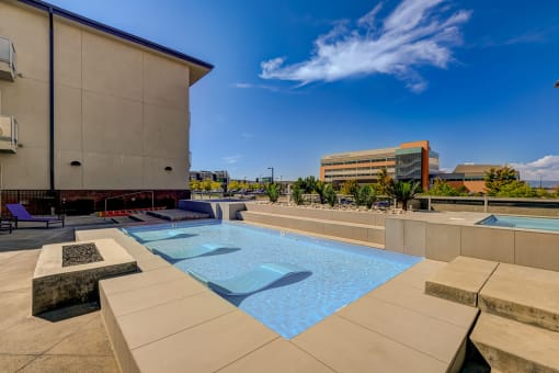 a pool on the rooftop of a building with a city in the background