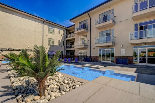 an apartment building with a pool and a palm tree