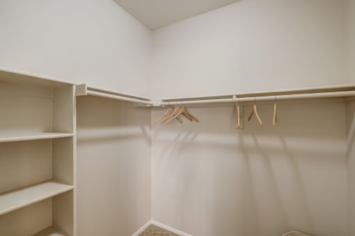 a walk in closet with shelves and hangers