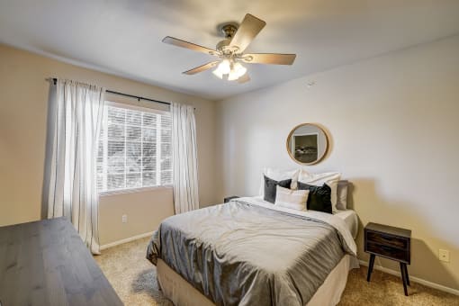 an empty bedroom with a bed and a ceiling fan