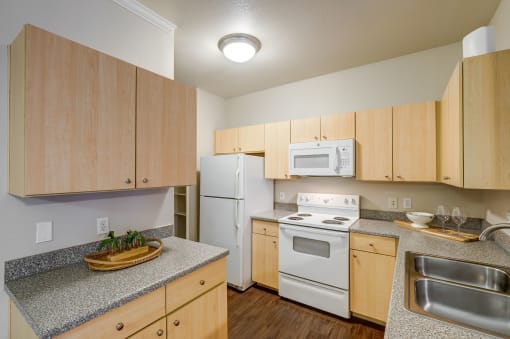a kitchen with white appliances and granite counter tops