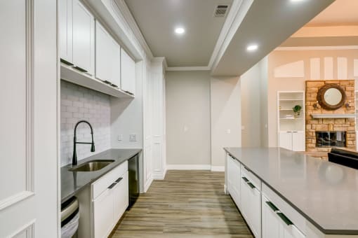 a large kitchen with white cabinets and a sink