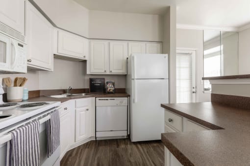 a kitchen with white appliances and white cabinets