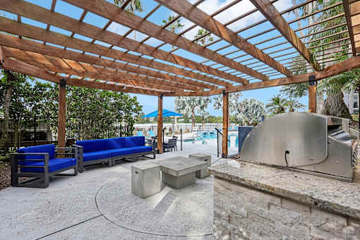 A patio with a grill and seating area.