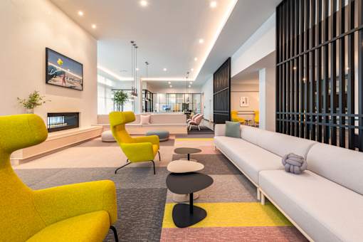 A modern living room with a yellow chair and a white sofa.