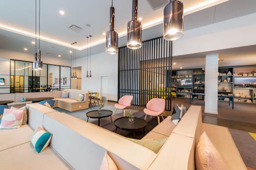 A modern living room with a white sofa and a glass wall.