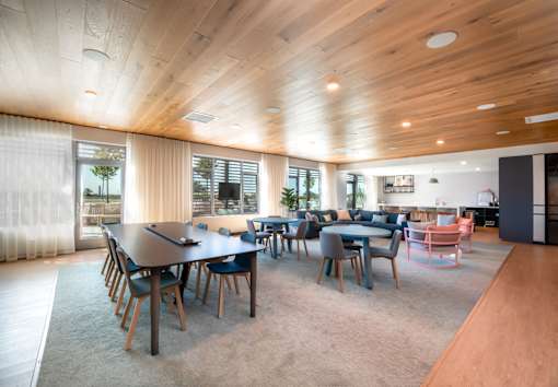 A modern dining room with a long table and chairs.