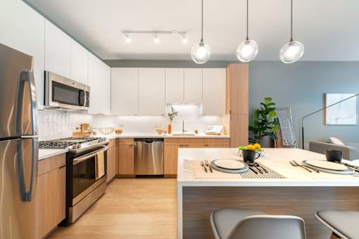 A modern kitchen with a dining table set for two.