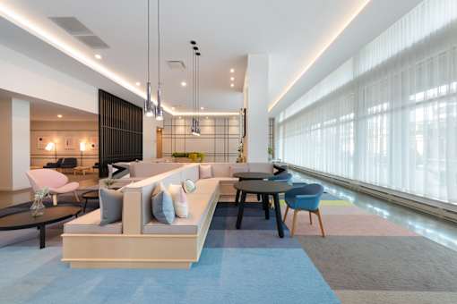 A modern living room with a large sofa and a dining table.