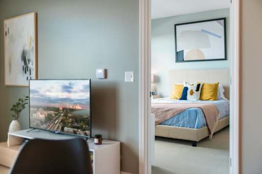 A television is on a stand in a bedroom.