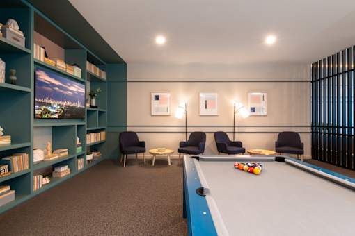A pool table is in the middle of a room with a blue carpet.