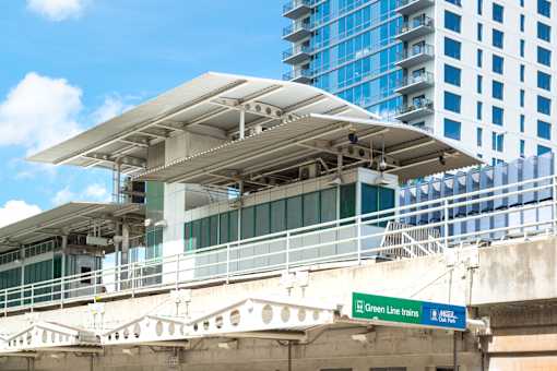 A train station with a green sign that says