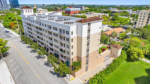 A large white and beige building with a parking lot in front.