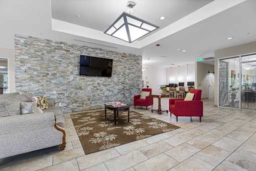 A living room with a stone wall and a flat screen TV.