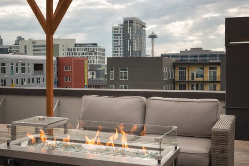 Luxury Apartments for Rent in Seattle, WA - Union Bay - Firepit Area with Raised Firepit, City View, and Patio Furniture