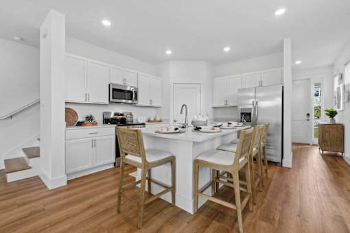 A kitchen with a table and chairs in the middle.