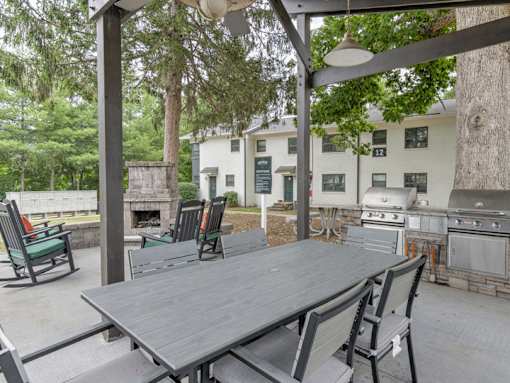 A patio with a table and chairs under a pergola.