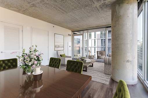 A dining room with a wooden table and green chairs.
