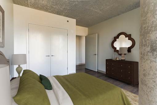 A bedroom with a bed, nightstand, and lamp.