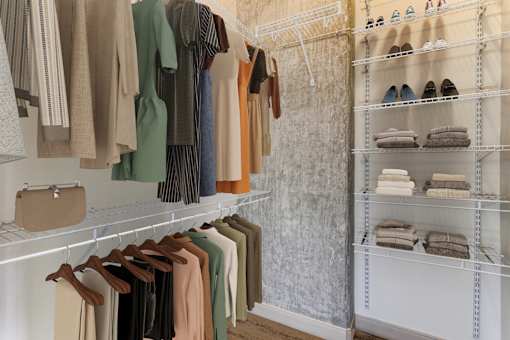 Clothing and shoes are displayed on shelves in a store.