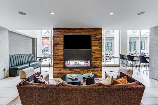 A living room with a brown couch and a wooden wall.
