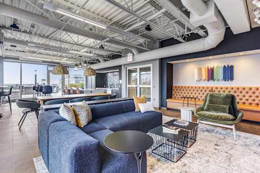 A blue couch with a black table in front of it.