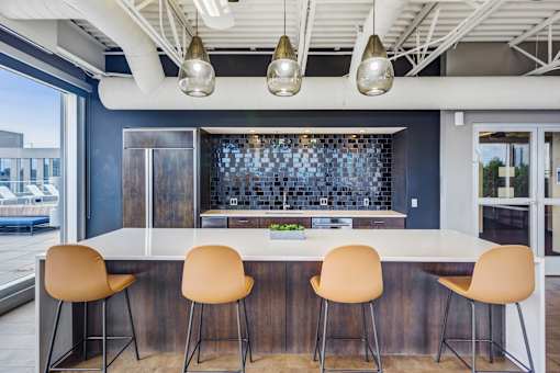 A kitchen with a bar area and chairs.