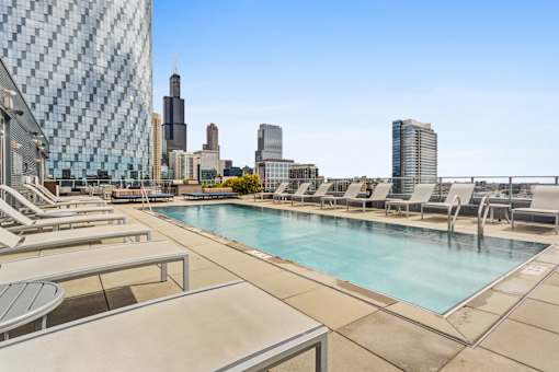 A pool area with a view of the city skyline.