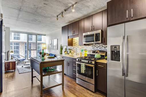 A modern kitchen with dark wood cabinets and stainless steel appliances.