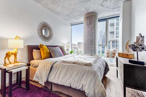 A bedroom with a large bed and a view of the city.
