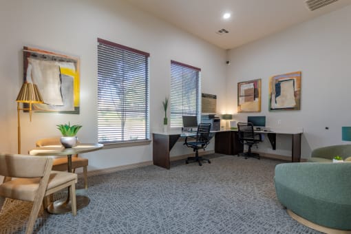 an office with two desks and chairs and a couch
