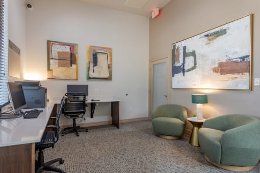 an office with a desk with a computer and chairs and paintings on the wall