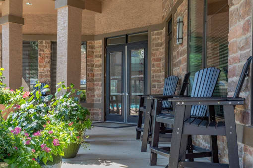 a porch with chairs and a table and a door