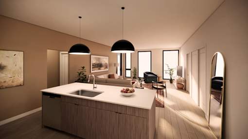 A modern kitchen with a large island and pendant lights.