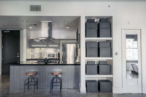A modern kitchen with a bar area and a door leading to a balcony.