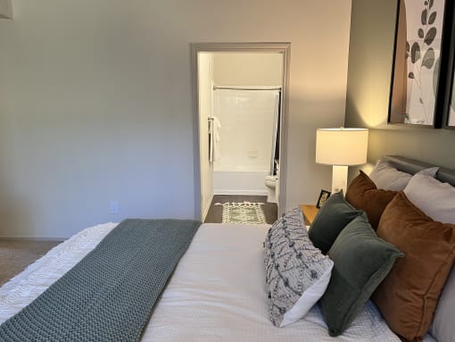 a bedroom with a large bed and a bathroom in the background